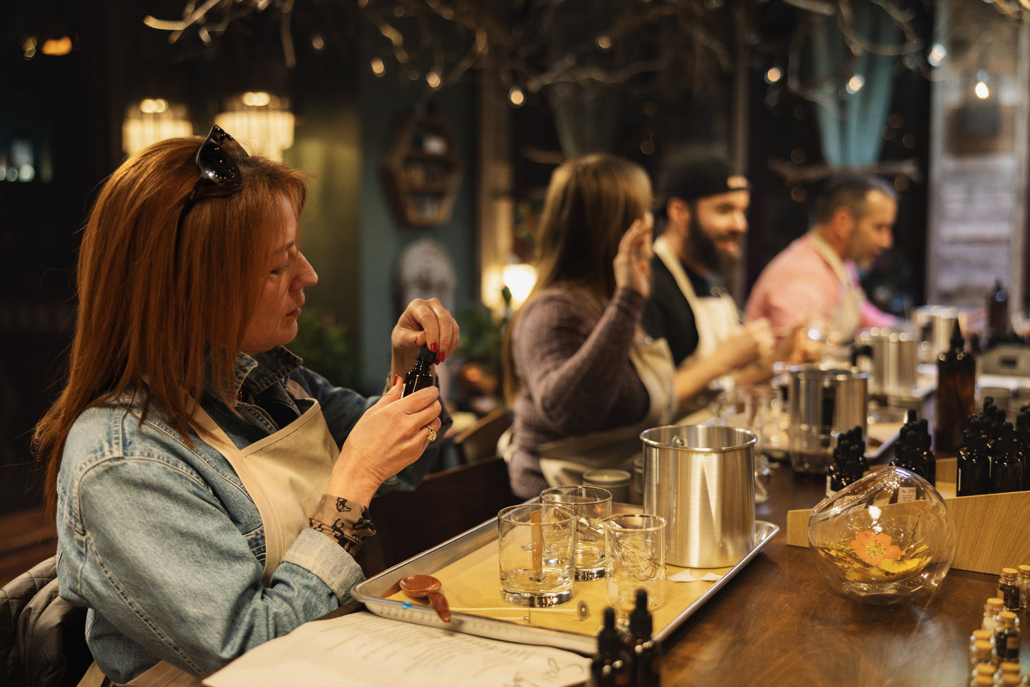 Woman in a bar setting with a tray of drinks and a blurred background
