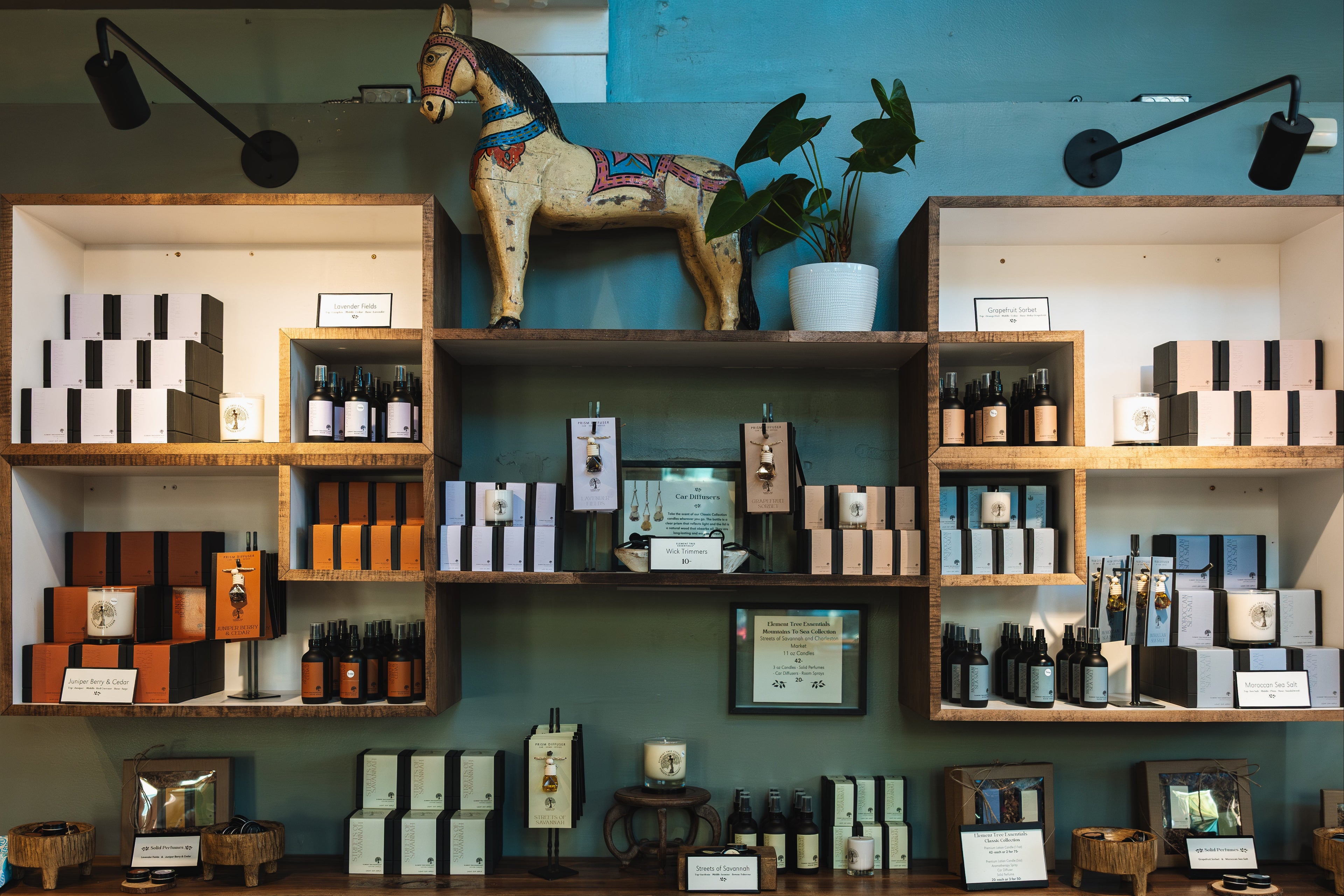Shelves with various items including bottles, boxes, and a decorative horse against a blue wall.