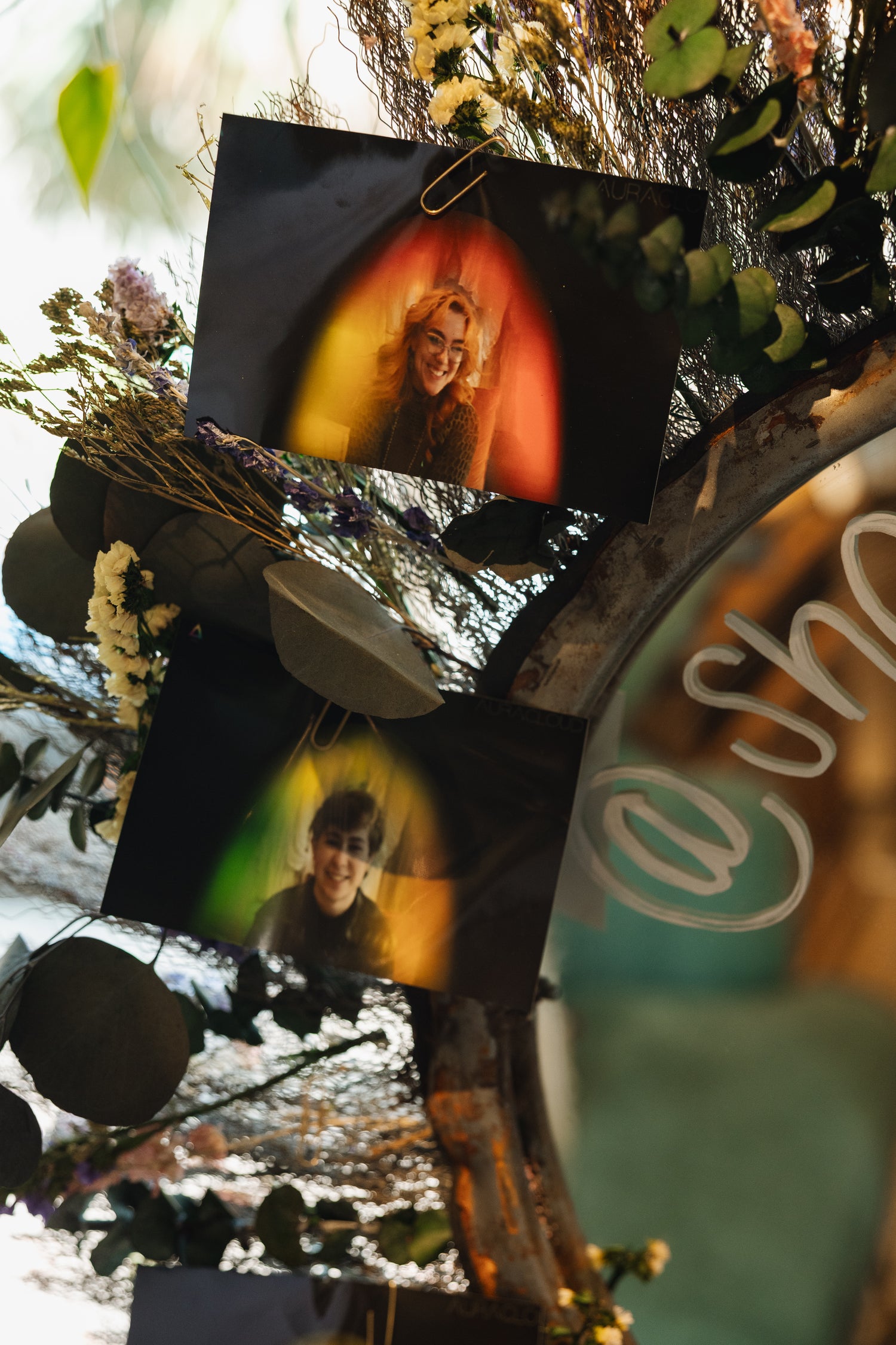 tow aura photos clipped to a decorative mirror 