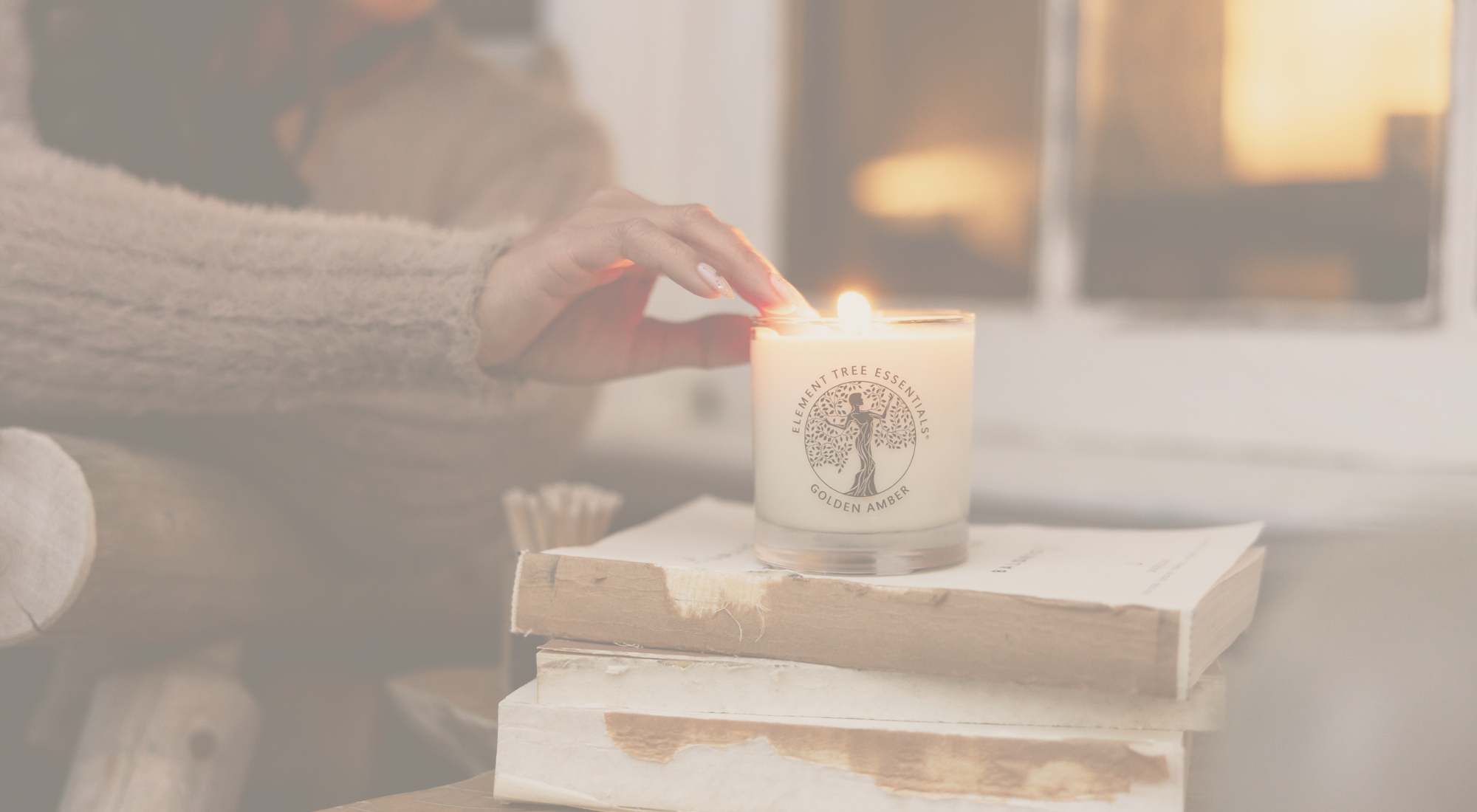 Candle being lit on a stack of books with a blurred background